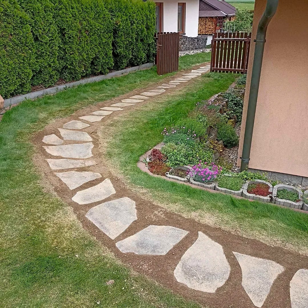 Srovnaný kamenný chodníček podél domu